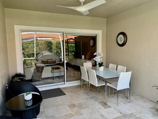 a dining room with furniture and a floor to ceiling window