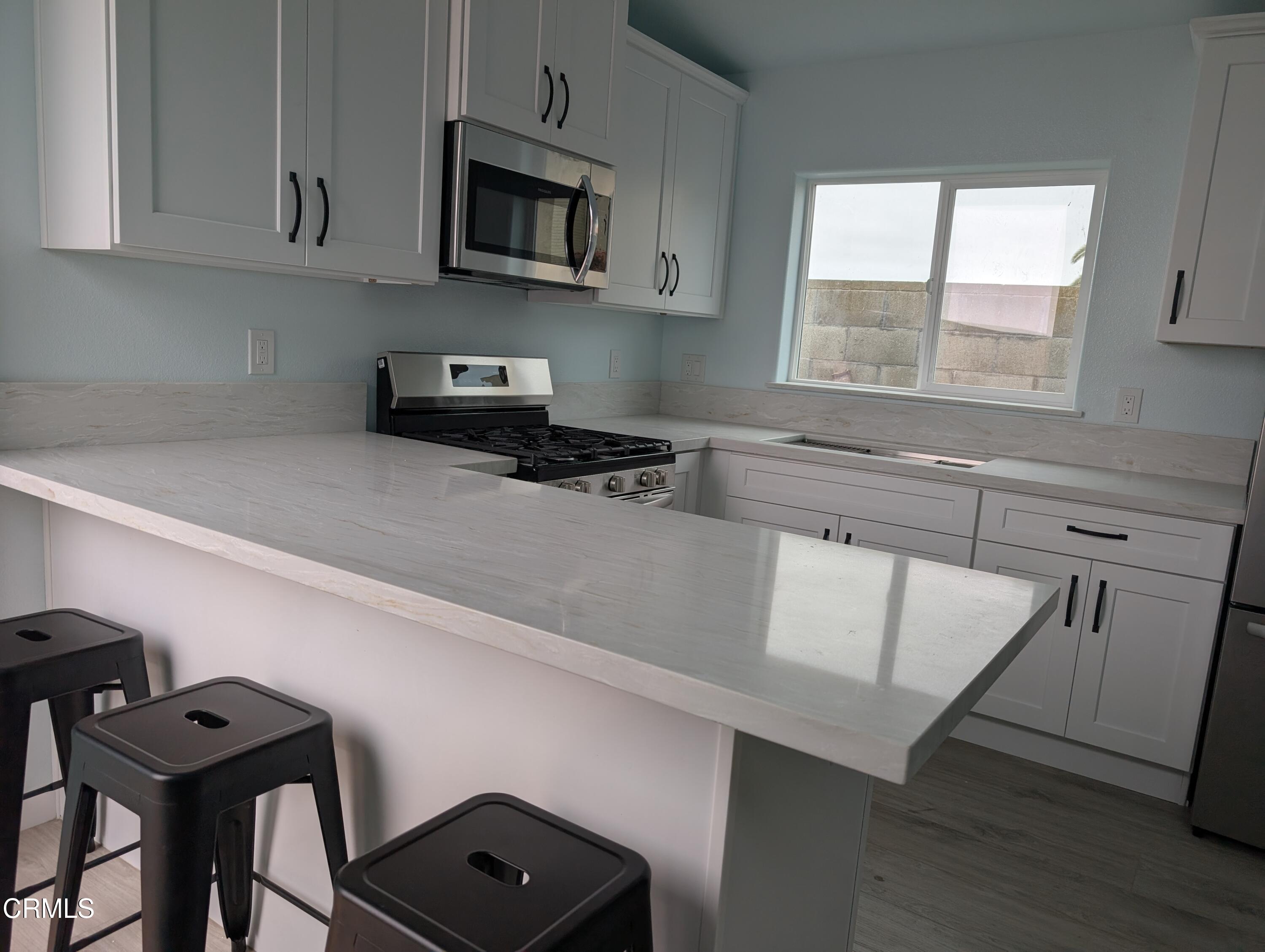 2220 Joyce Place, Unit 2 Oxnard, CA 93033 - Photo 2 of 11 a kitchen with stainless steel appliances cabinets a window and a sink