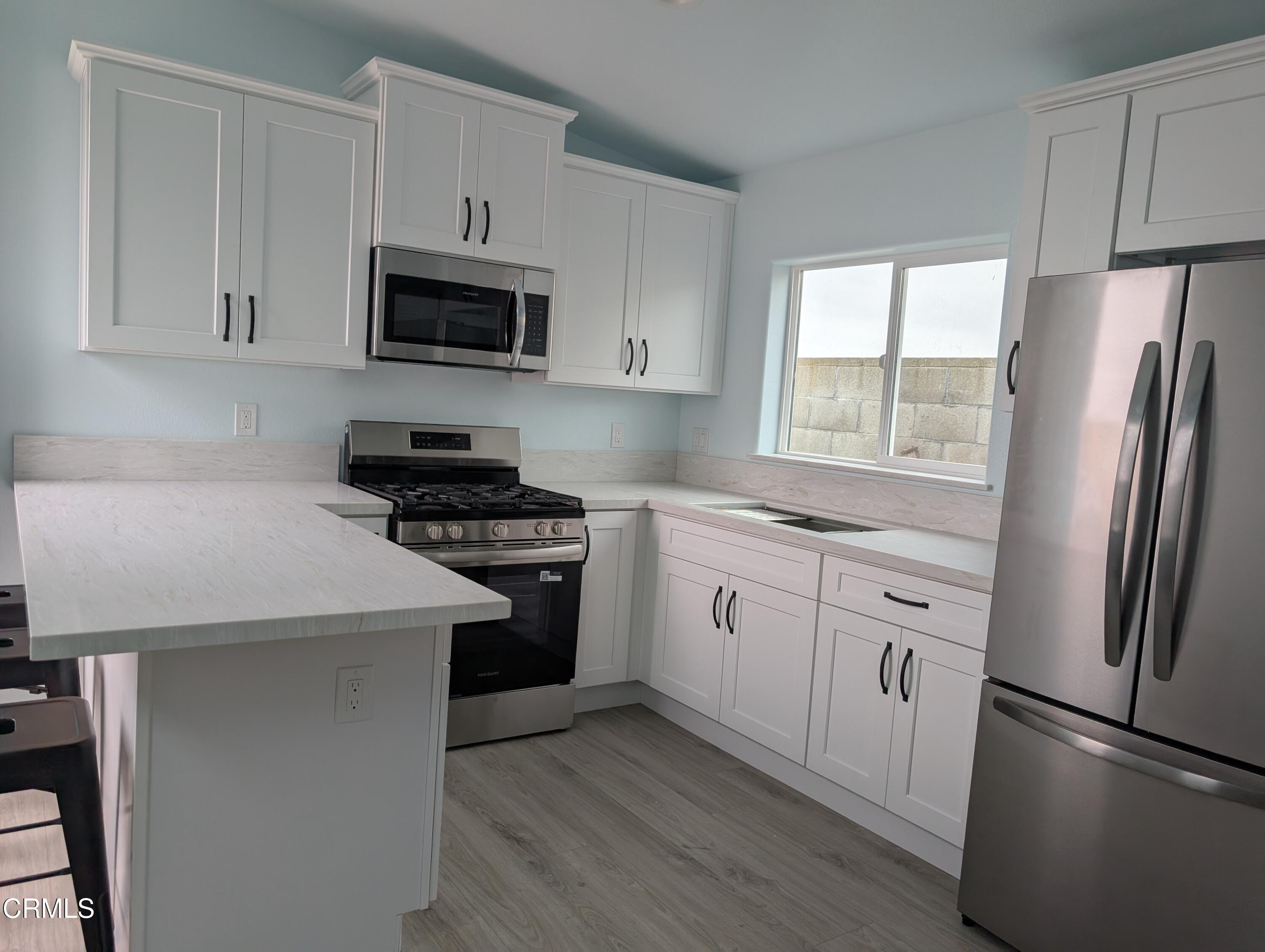2220 Joyce Place, Unit 2 Oxnard, CA 93033 - Photo 3 of 11 a kitchen with a refrigerator stove and microwave