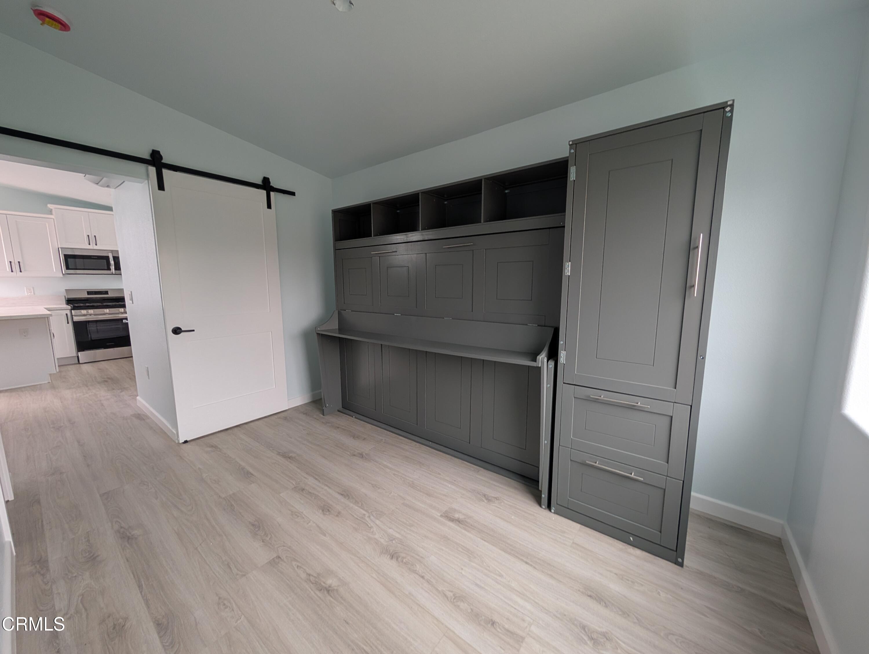 2220 Joyce Place, Unit 2 Oxnard, CA 93033 - Photo 8 of 11 a view of an empty room with wooden floor and a window