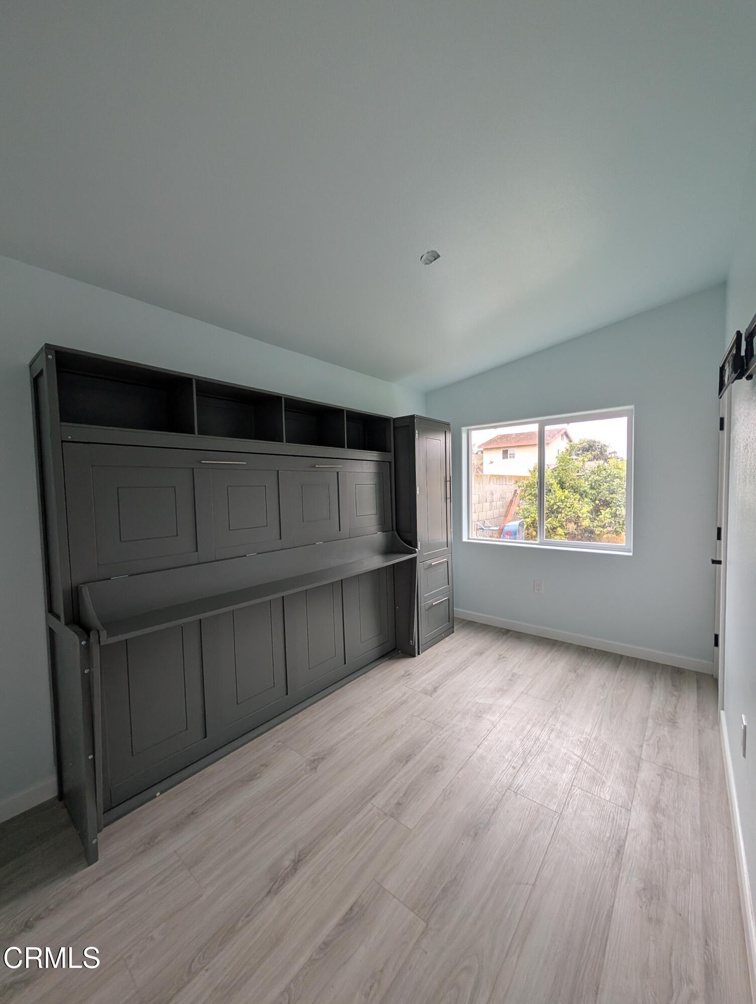 2220 Joyce Place, Unit 2 Oxnard, CA 93033 - Photo 9 of 11 an empty room with wooden floor and windows