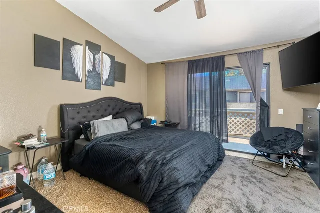 a bedroom with a bed a mirror on dresser and a flat screen tv