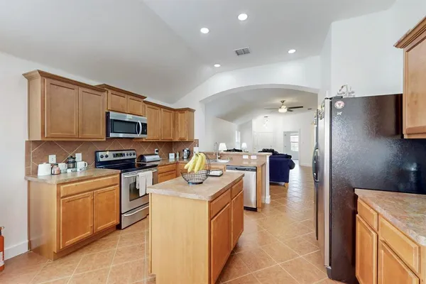 a kitchen with a sink a counter top space appliances and cabinets