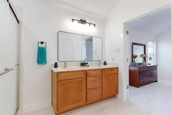 a spacious bathroom with a granite countertop sink and a mirror