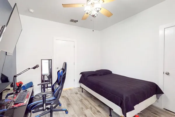 a spacious bedroom with a bed and a chandelier