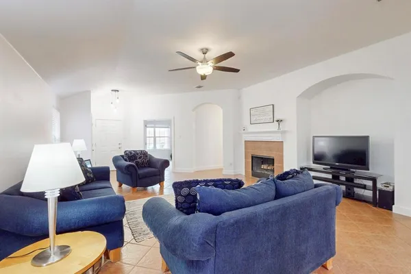 a living room with furniture a fireplace and a flat screen tv