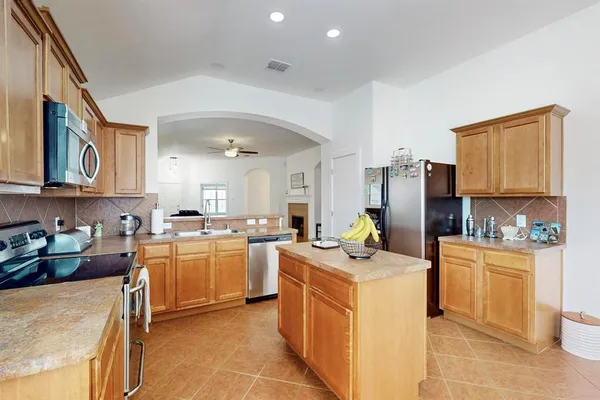 a kitchen that has a lot of cabinets in it and stainless steel appliances