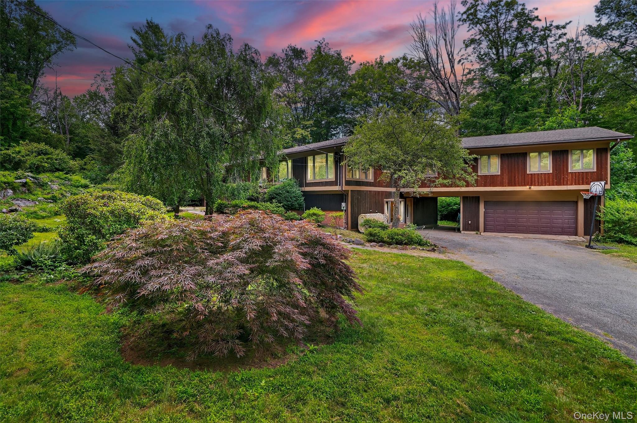 a front view of a house with a yard and trees