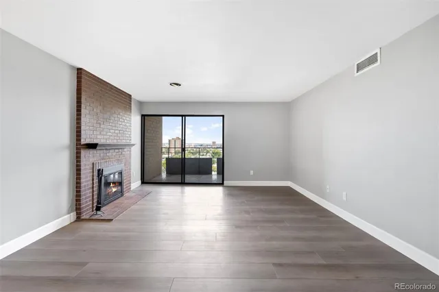 a view of a hallway with wooden floor and a fireplace