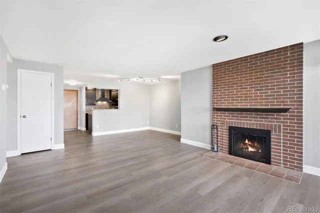 a view of empty room with wooden floor and fireplace