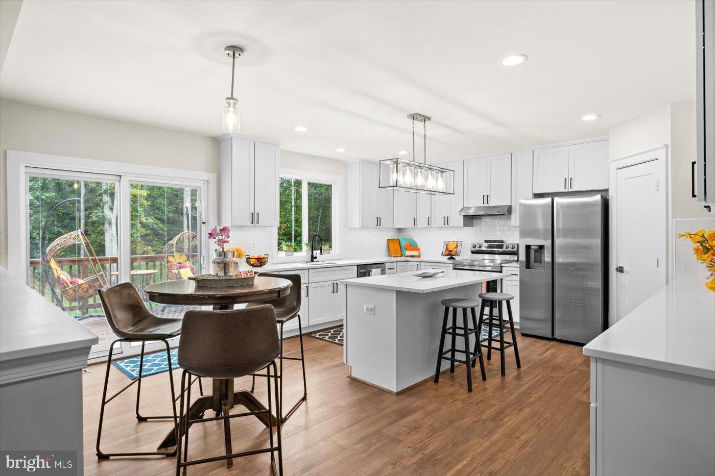 537 Monticello Circle Locust Grove, VA 22508 - Photo 16 of 107 a kitchen with stainless steel appliances a dining table chairs refrigerator and sink