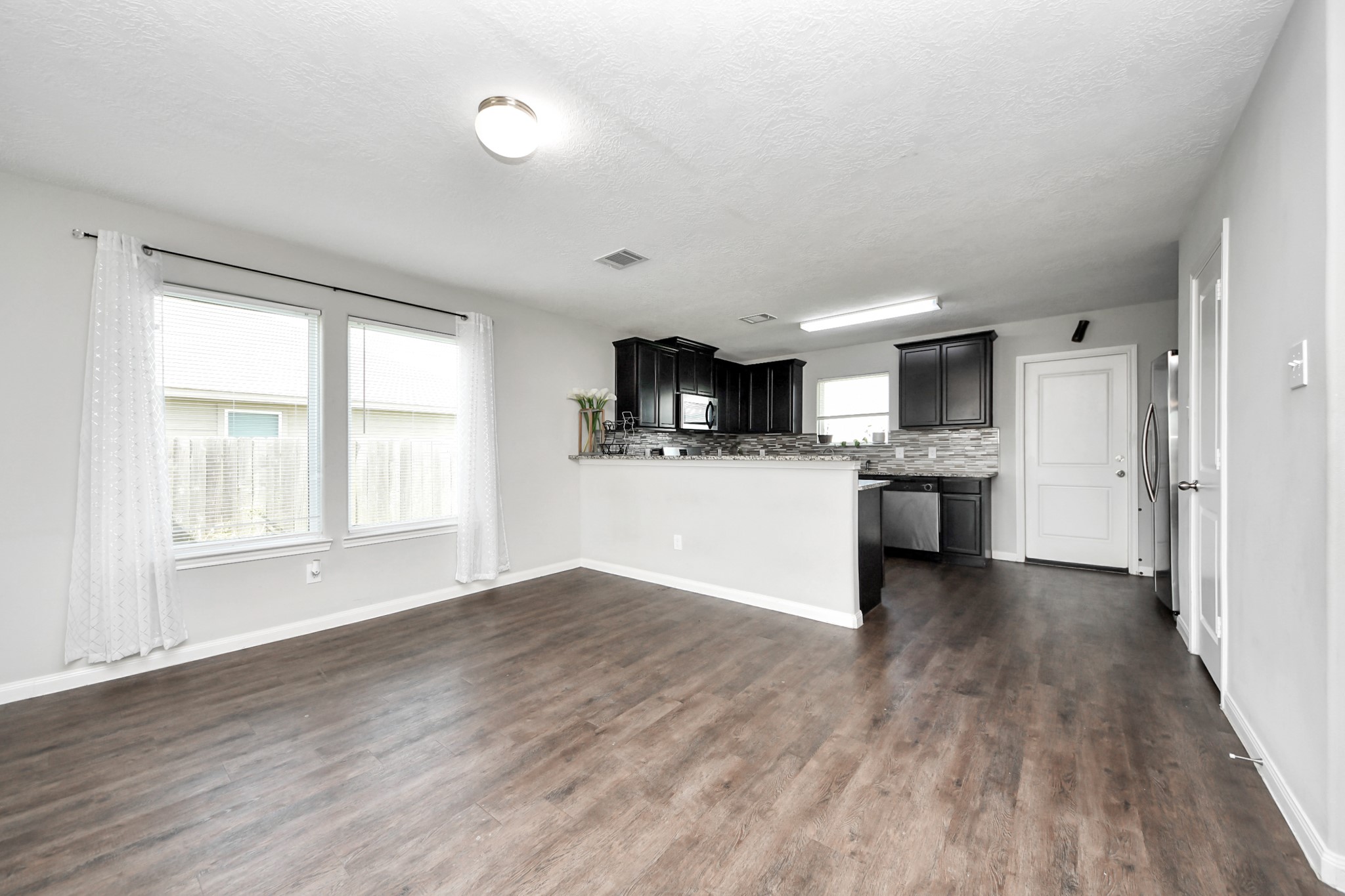 696 Road 5105 Cleveland, TX 77327 - Photo 5 of 25 a view of a kitchen with a sink stove cabinets and empty room