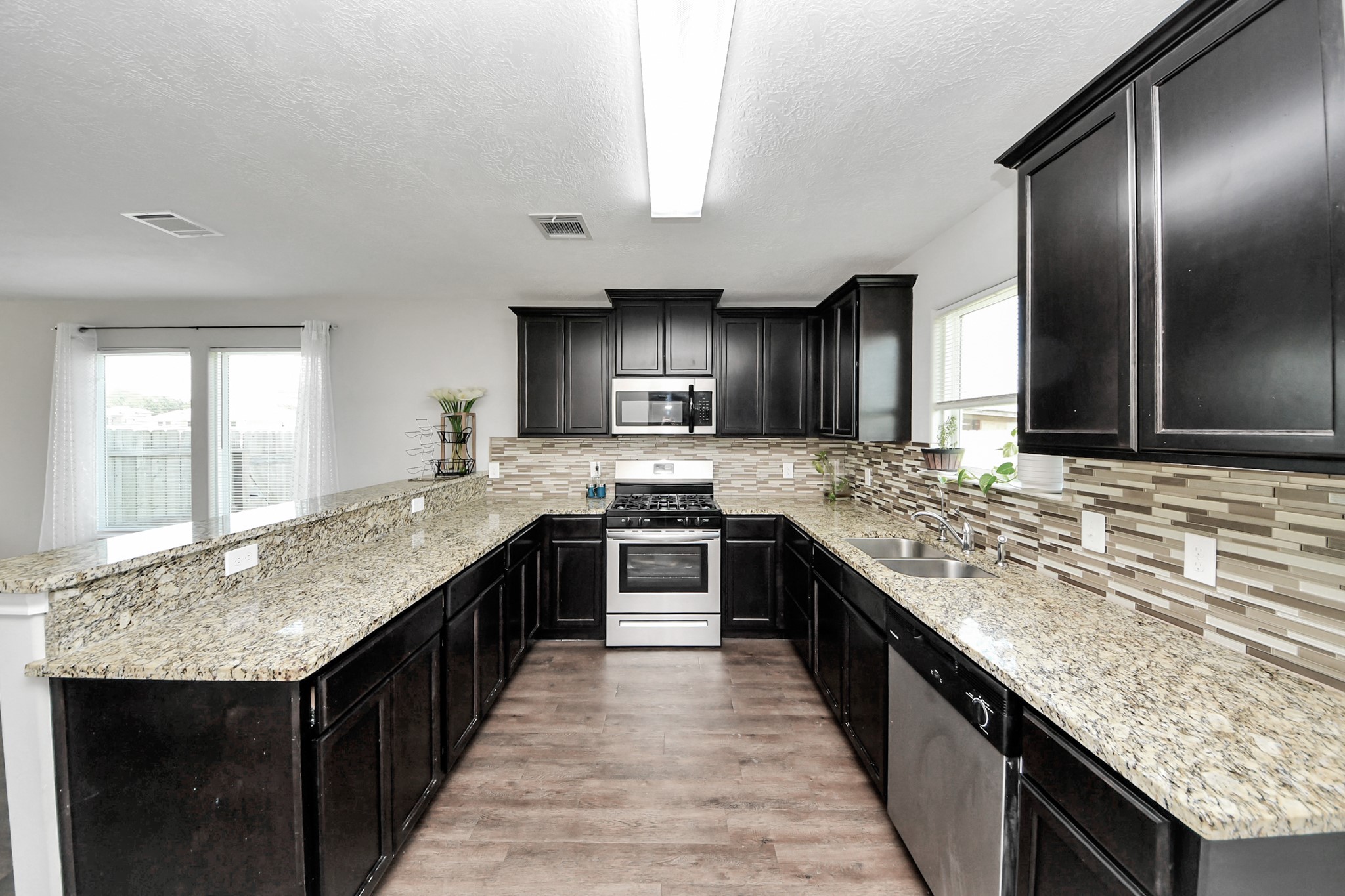 696 Road 5105 Cleveland, TX 77327 - Photo 6 of 25 a modern kitchen with granite countertop stainless steel appliances and a sink