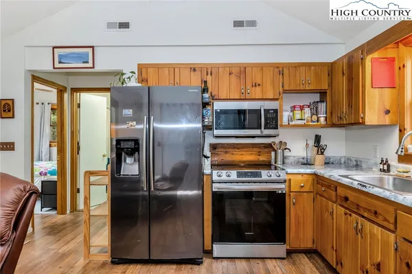 a view of a wooden house with a small yard and wooden fence