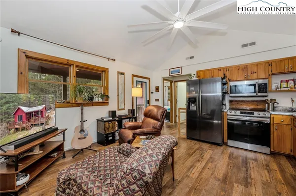 a kitchen with granite countertop a sink dishwasher stove and cabinets with wooden floor