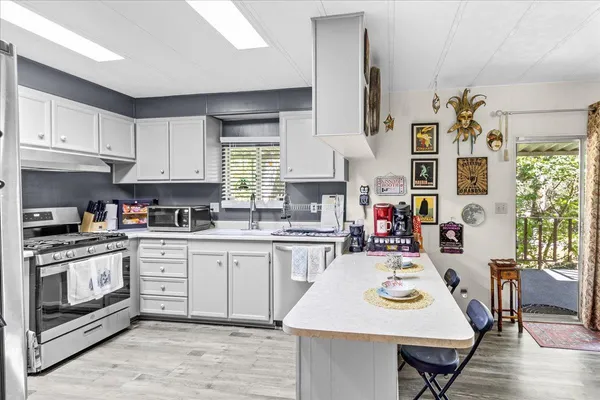 a very nice looking dining room with kitchen island granite countertop a stove a sink a dining table and chair