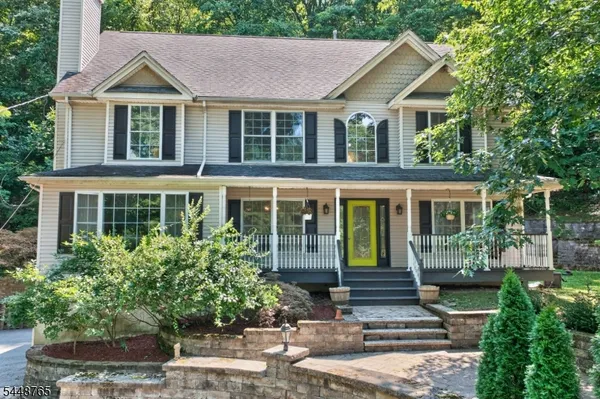 a front view of a house with a yard and potted plants