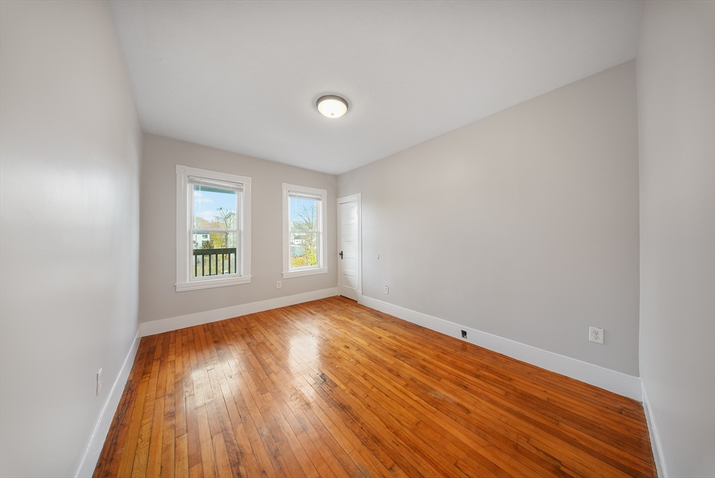 16 Bellevue Avenue, Unit 4 Brockton, MA 02302 - Photo 6 of 10 an empty room with wooden floor and windows