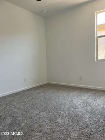 an empty room with a ceiling fan and a window