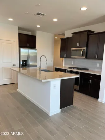 a kitchen with stainless steel appliances granite countertop a sink a stove top oven a counter space and cabinets