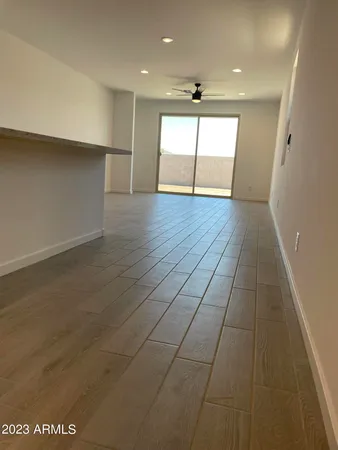 an empty room with wooden floor and natural light