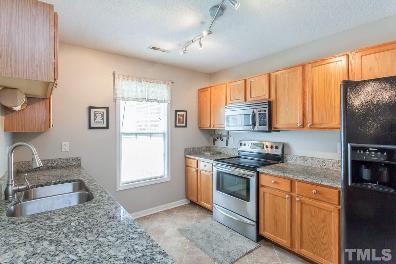 6007 Newhall Road Durham, NC 27713 - Photo 12 of 25 a kitchen with stainless steel appliances granite countertop a stove a sink and a microwave