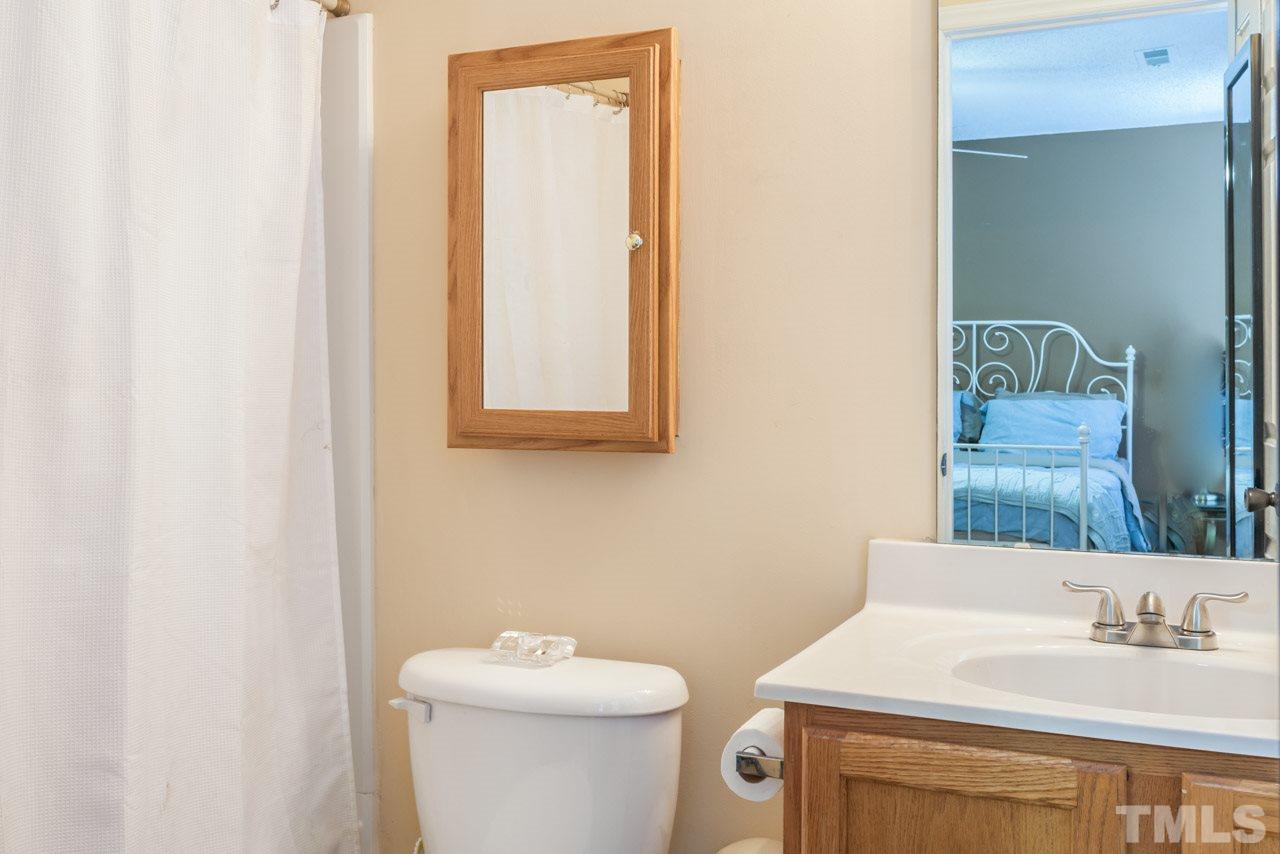 6007 Newhall Road Durham, NC 27713 - Photo 17 of 25 a bathroom with a toilet sink and mirror