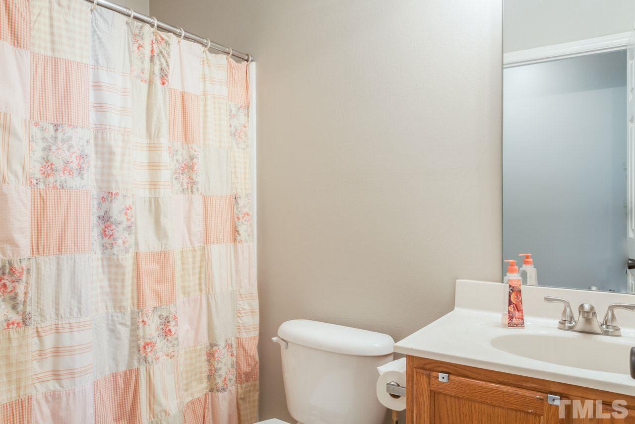 6007 Newhall Road Durham, NC 27713 - Photo 20 of 25 a bathroom with a sink a toilet and shower curtain