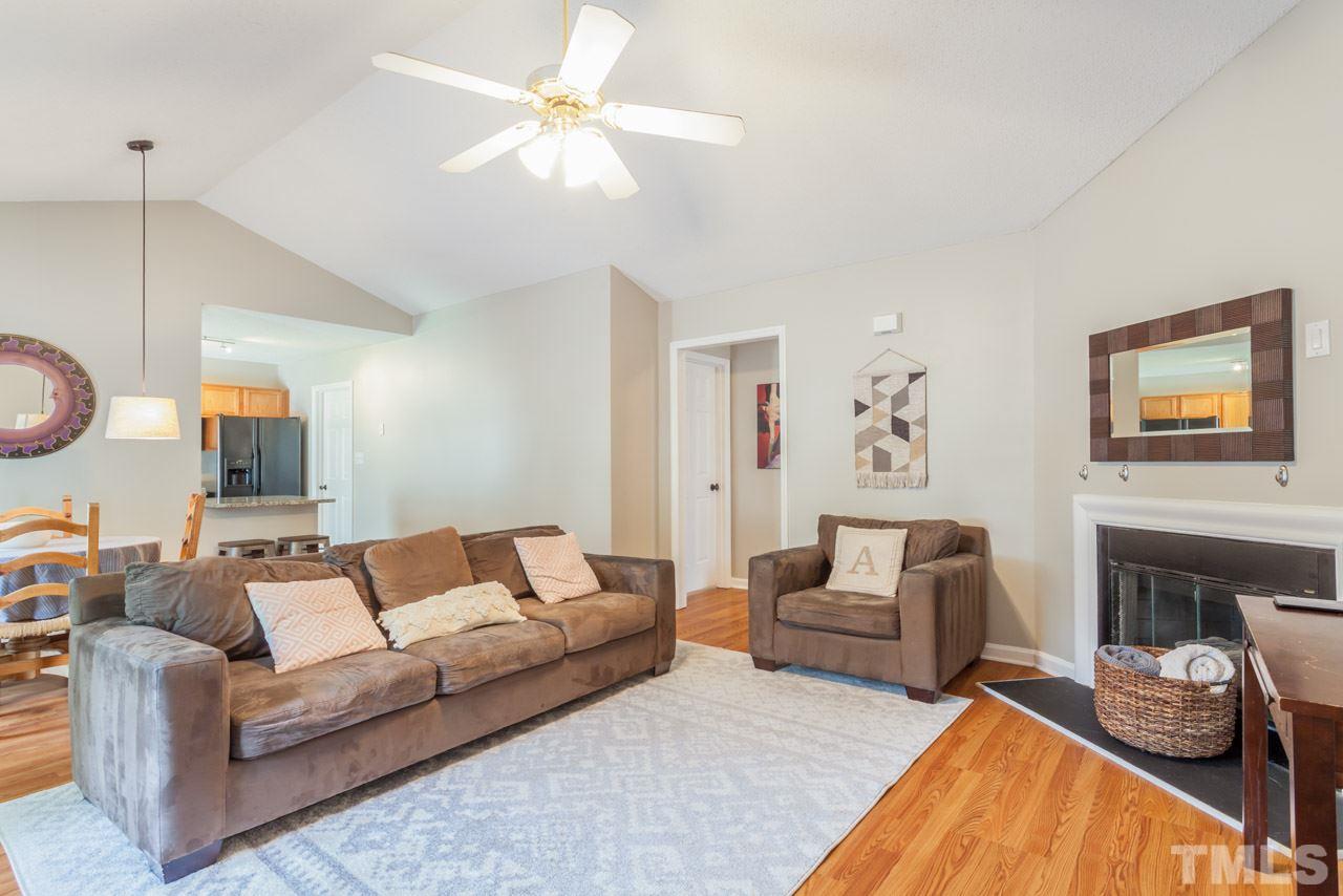 6007 Newhall Road Durham, NC 27713 - Photo 9 of 25 a living room with furniture a fireplace and a chandelier