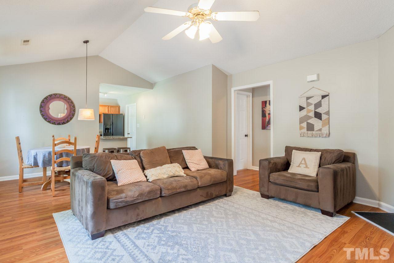 6007 Newhall Road Durham, NC 27713 - Photo 10 of 25 a living room with furniture a bed and a chandelier