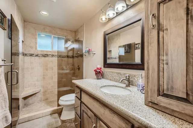 a bathroom with a granite countertop sink toilet and shower