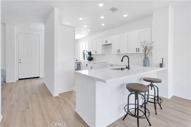 a kitchen with a sink cabinets and wooden floor
