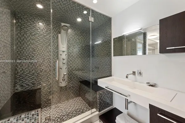 a bathroom with a sink a toilet and shower