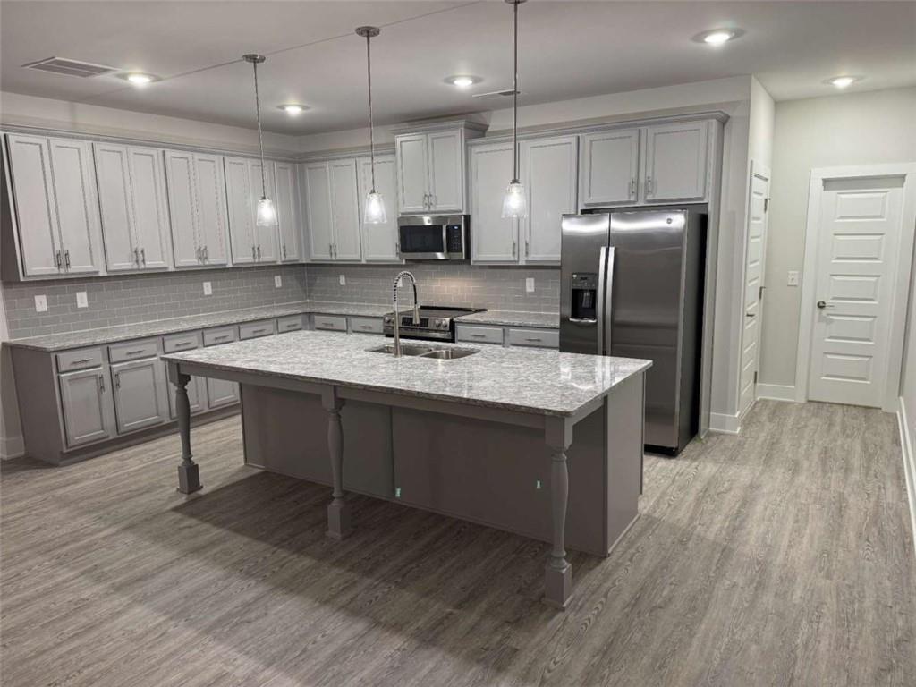 2530 Harbor Ridge Gainesville, GA 30507 - Photo 12 of 44 a kitchen with kitchen island granite countertop a sink refrigerator and wooden cabinets