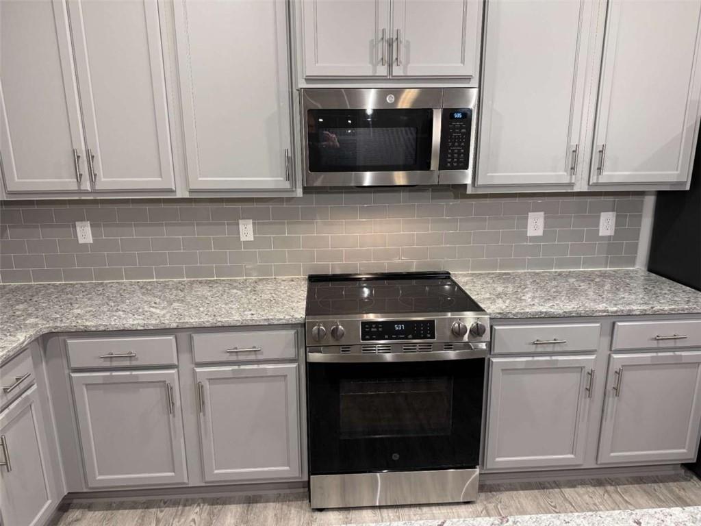 2530 Harbor Ridge Gainesville, GA 30507 - Photo 5 of 44 a kitchen with granite countertop a stove top oven microwave and cabinets