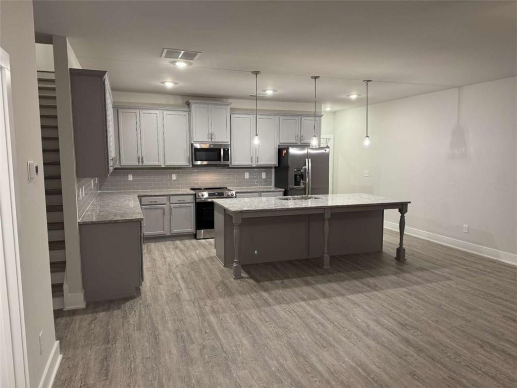 2530 Harbor Ridge Gainesville, GA 30507 - Photo 6 of 44 a kitchen with kitchen island stainless steel appliances a sink cabinets and wooden floor