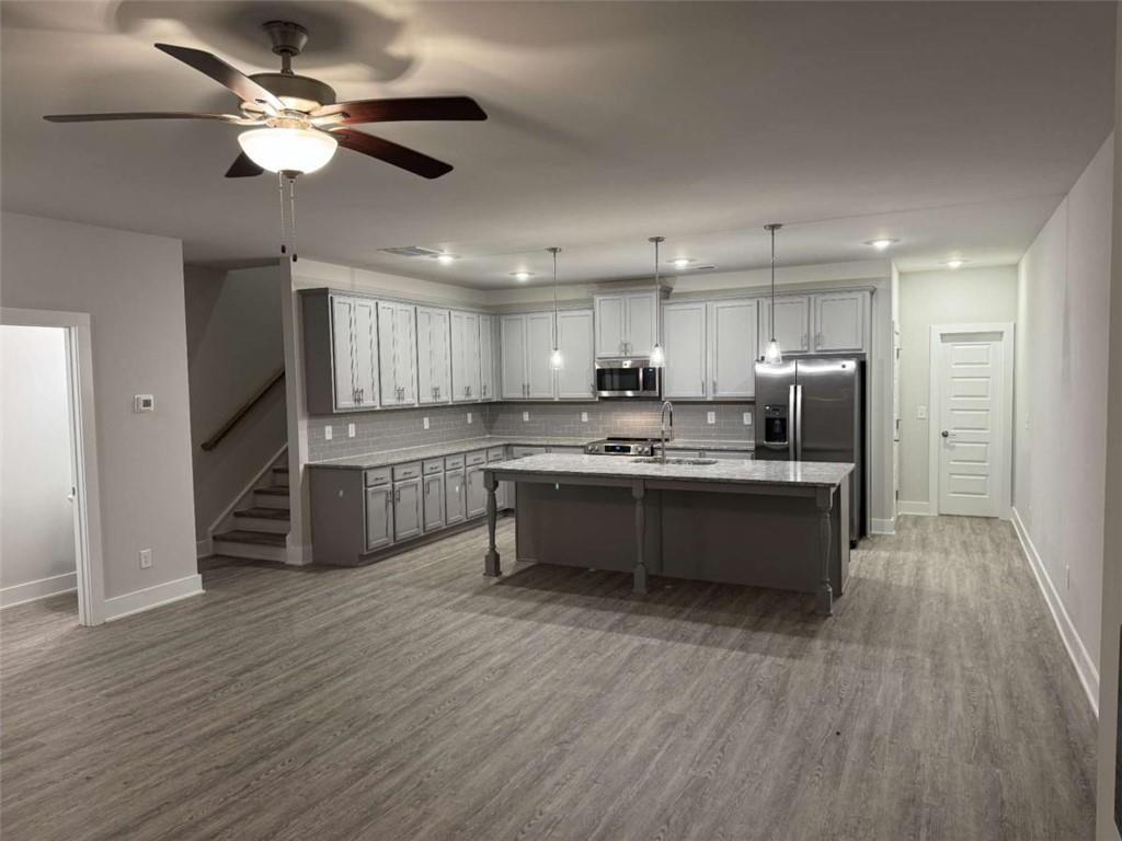 2530 Harbor Ridge Gainesville, GA 30507 - Photo 10 of 44 a large kitchen with a center island wooden floor stainless steel appliances and cabinets