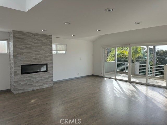 an empty room with wooden floor and fireplace