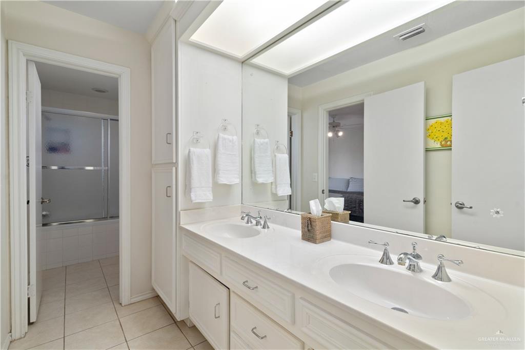 1113 Xanthisma Avenue McAllen, TX 78504 - Photo 16 of 30 Full bathroom with light tile patterned flooring, double vanity, tiled shower / bath combo, connected bathroom, and a ceiling fan