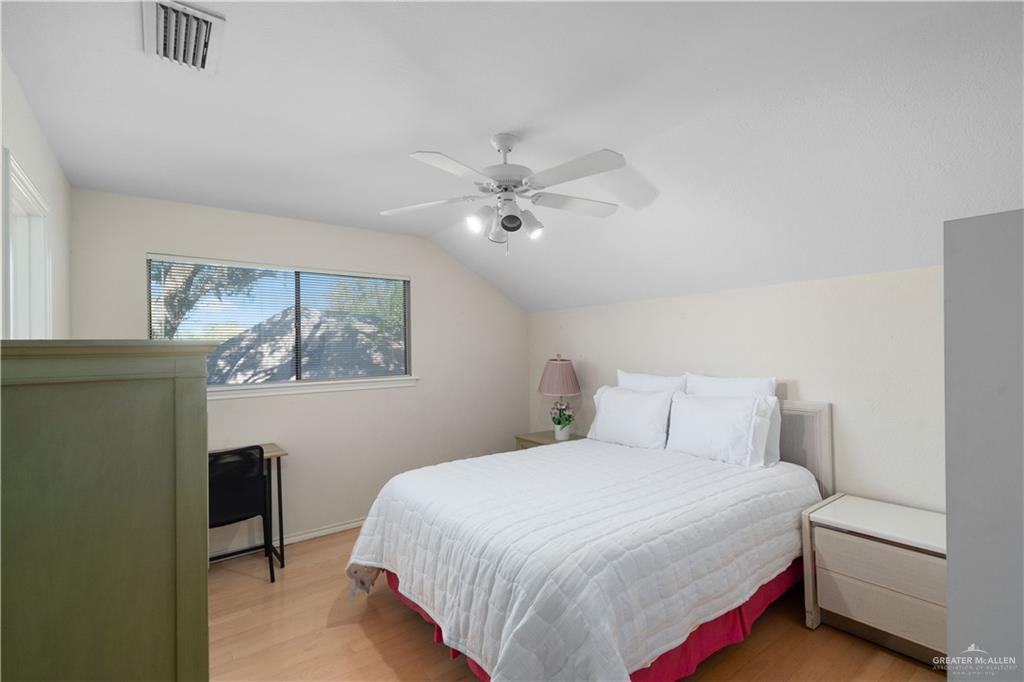 1113 Xanthisma Avenue McAllen, TX 78504 - Photo 17 of 30 Bedroom featuring light wood finished floors, vaulted ceiling, and a ceiling fan