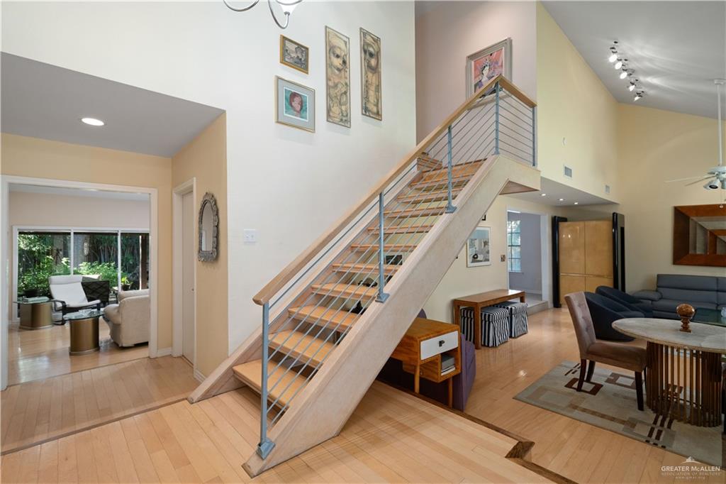 1113 Xanthisma Avenue McAllen, TX 78504 - Photo 4 of 30 Stairs featuring wood-type flooring, a ceiling fan, a high ceiling, and track lighting