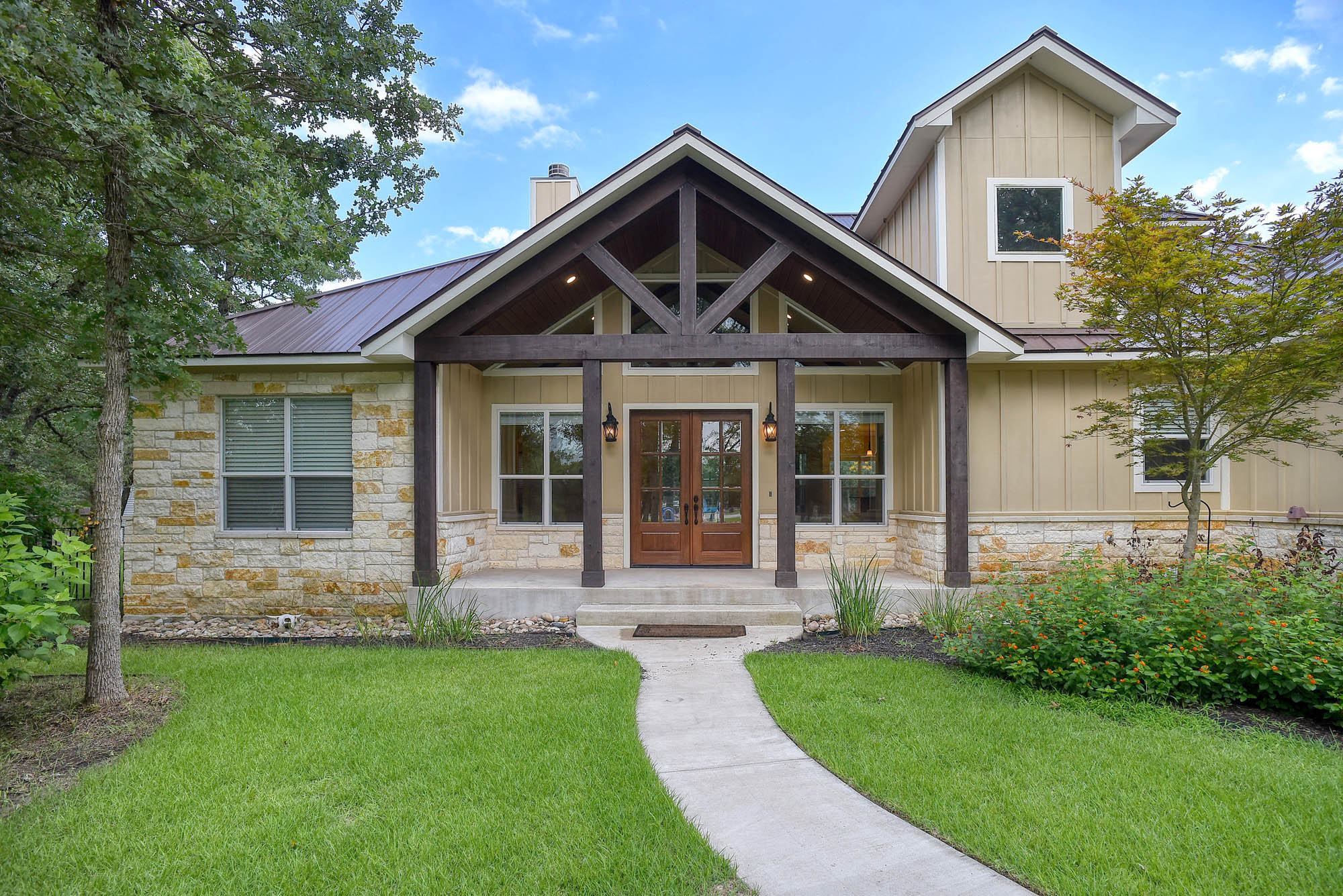 115 Pine Point Cove Elgin, TX 78621 - Photo 3 of 39 This beautiful property features an inviting entryway, lush landscaping, and a sophisticated stone and siding facade.