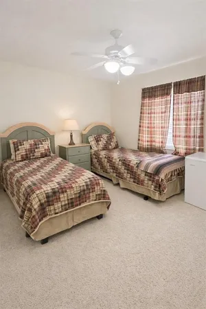 a spacious bedroom with two bed and a chandelier