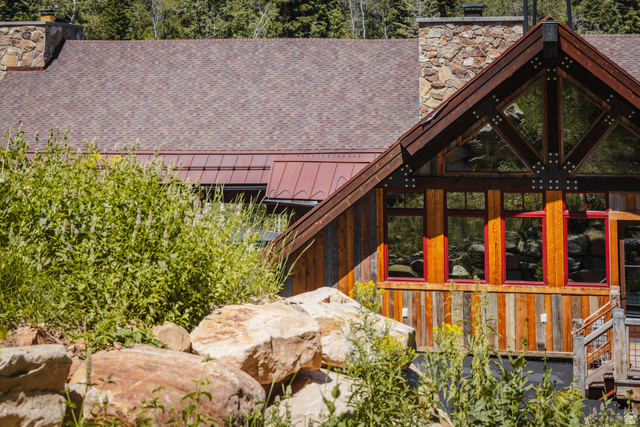 1667 West Tollgate Cyn Road Coalville, UT 84017 - Photo 52 of 61 Wood-sided exterior featuring large windows with red trim and a stone chimney