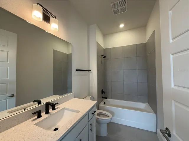 a bathroom with a sink mirror toilet and bathtub