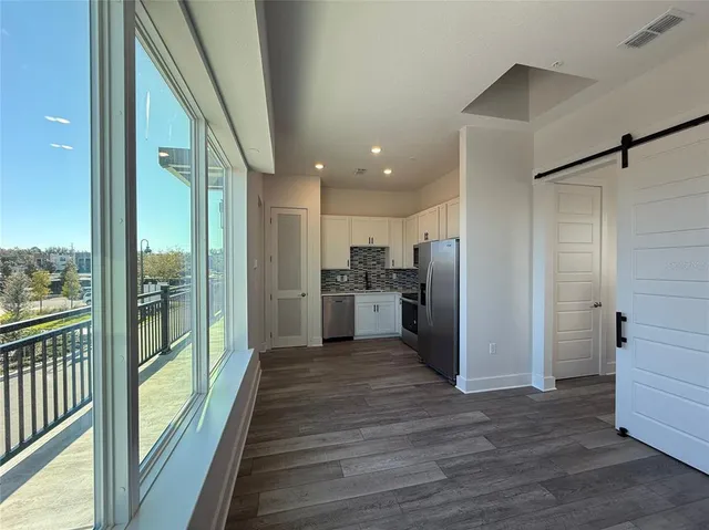 a view of a kitchen with wooden floor and a glass door