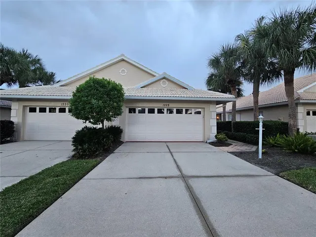 a view of front of house with a yard and potted plants
