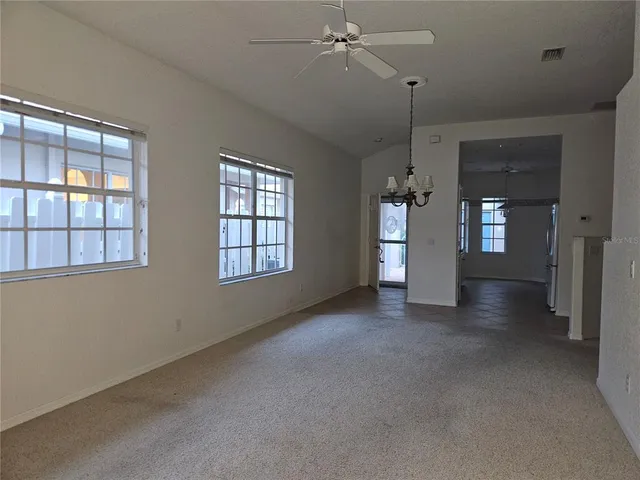 a view of an empty room with a window and cabinet