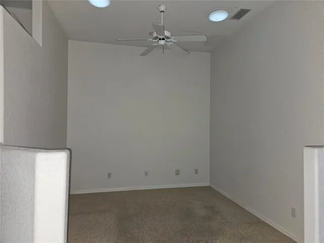 an empty room with a ceiling fan and a window