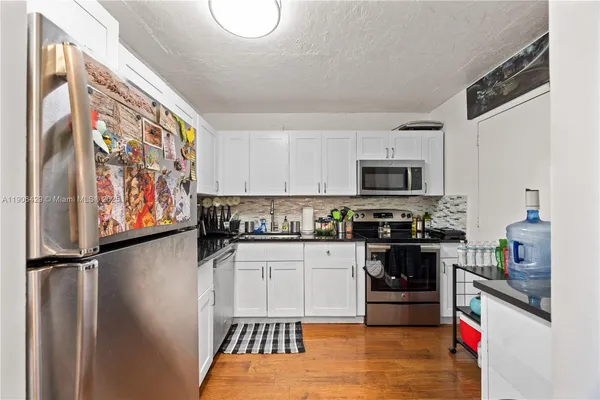 a kitchen with stainless steel appliances granite countertop a refrigerator a stove top oven a sink and dishwasher